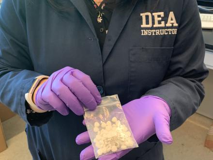 DEA Intelligence Instructor holding a bag of illicit nitazene pills